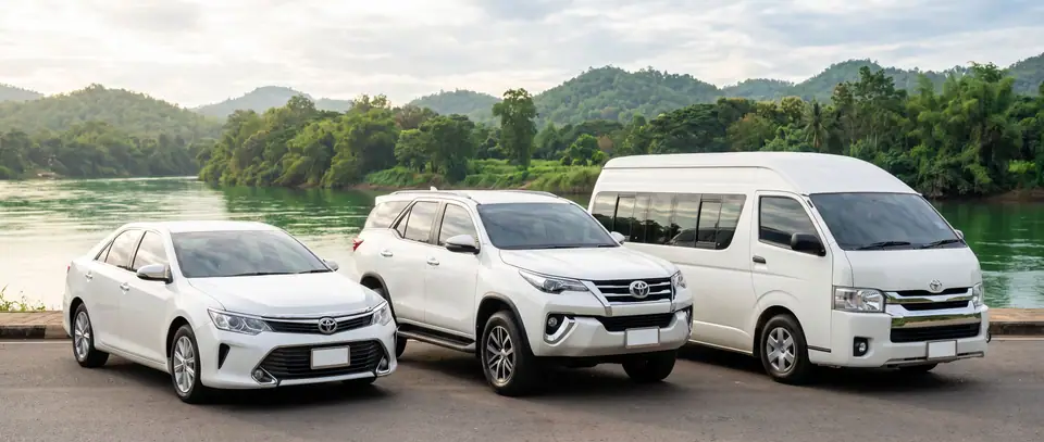 White sedan, SUV and van parked by the river in Kanchanaburi
